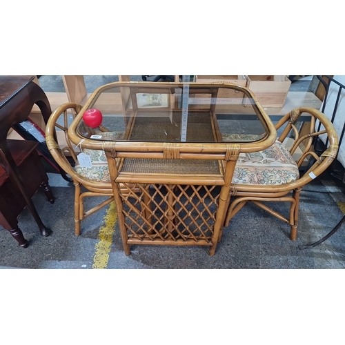 492 - Bamboo and glass table with two matching chairs and floral-patterned cushions, made in Indonesia.