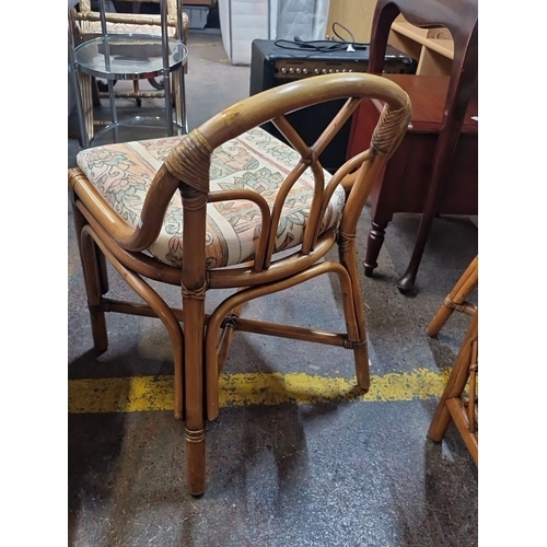 492 - Bamboo and glass table with two matching chairs and floral-patterned cushions, made in Indonesia.