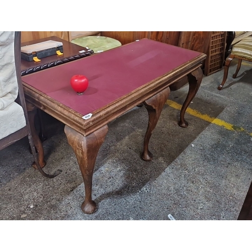 494 - Queen Anne style table, mahogany with cabriole legs, red leather top, from the early 20th century.