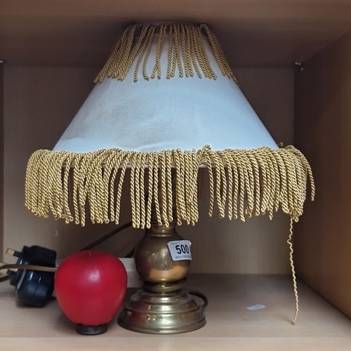 500 - Brass table lamp with white fabric shade and gold braided trim, red apple-shaped night light.