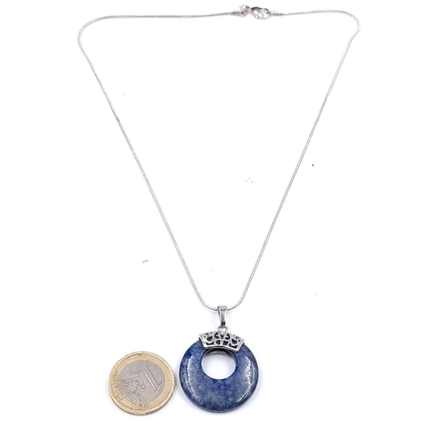 503 - A sterling silver lapis lazuli circular pendant and chain. Length 44cm. Weight 11 grams.