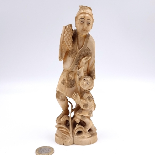 506 - Star Lot: A super example of an antique nicely carved bone figure of a man with child. Lots of chara... 