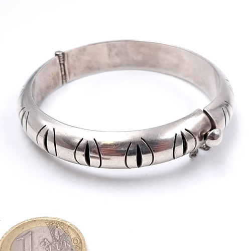 525 - An attractive sterling silver 925 TC Mexico bangle bracelet with safety chain. Total weight 31.74 gr... 
