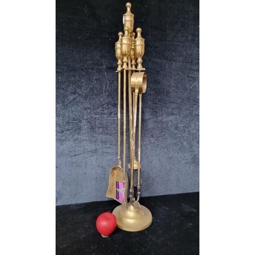 823 - A brass fireside companion set including poker, ash pan, tong and brush.