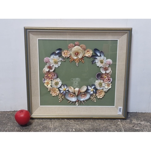 941 - An original shell art. Features a floral wreath design with various shells and beads on green backgr... 