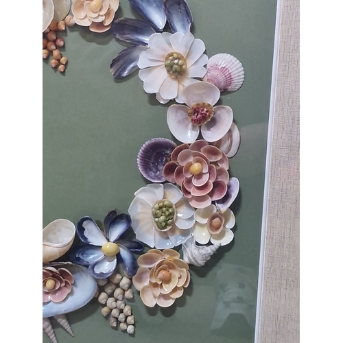 941 - An original shell art. Features a floral wreath design with various shells and beads on green backgr... 