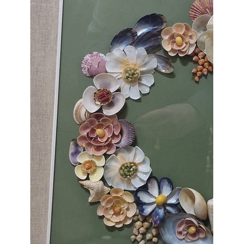941 - An original shell art. Features a floral wreath design with various shells and beads on green backgr... 
