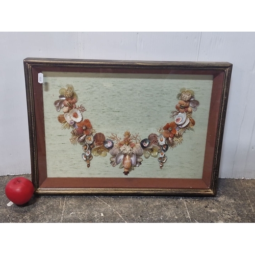 942 - An original shell art. Features a floral design with various shells and beads on green background. H... 