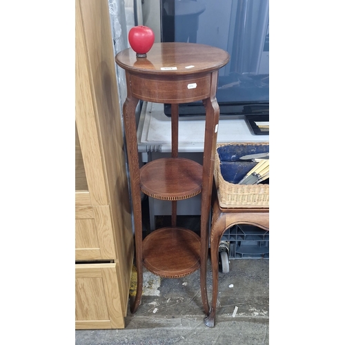 959 - Mahogany three-tier plant table from the early 20th century, with circular shelves and carved legs.