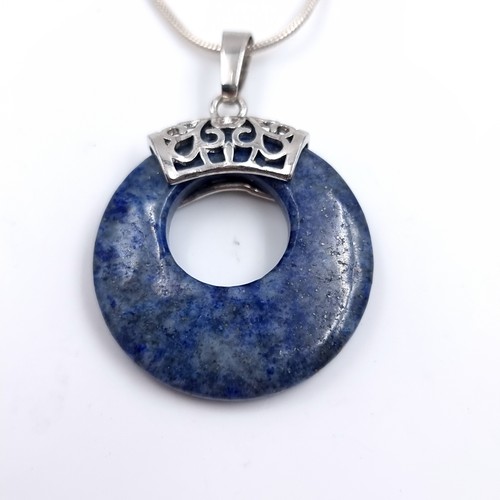 503 - A sterling silver lapis lazuli circular pendant and chain. Length 44cm. Weight 11 grams.