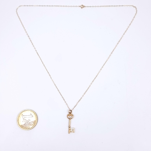 163 - Star Lot: A nine carat gold 375 key pendant (marked 21) and chain. Length 44cm. Weight 1.23 grams. B... 