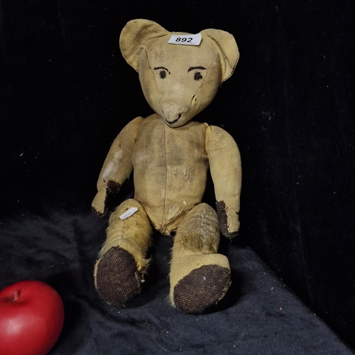 892 - A very early antique teddy bear with straw filling, free moving arms and legs and protruding spout.