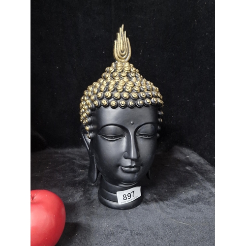 897 - A Black and Gold designed Buddha head. Height - 27CM.