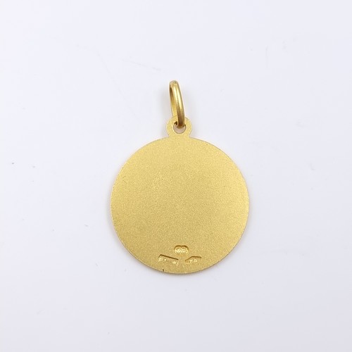 32 - Star Lot: An 18 carat gold 750 religious medallion pendant. Weight 4.43 grams.