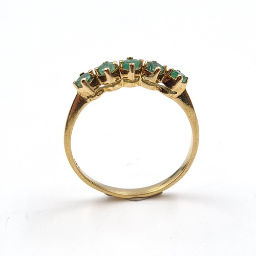 6 - Star Lot: An 18 carat gold emerald half eternity ring. Size O. Weight 1.86 grams.