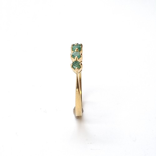 6 - Star Lot: An 18 carat gold emerald half eternity ring. Size O. Weight 1.86 grams.