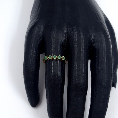 6 - Star Lot: An 18 carat gold emerald half eternity ring. Size O. Weight 1.86 grams.