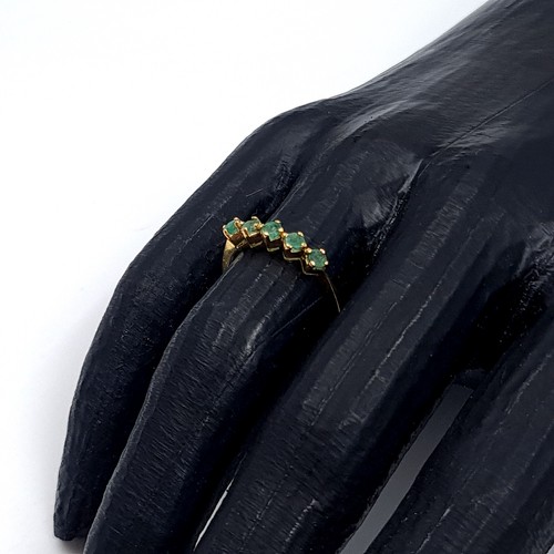 6 - Star Lot: An 18 carat gold emerald half eternity ring. Size O. Weight 1.86 grams.
