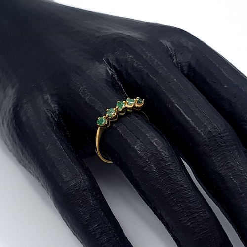 6 - Star Lot: An 18 carat gold emerald half eternity ring. Size O. Weight 1.86 grams.