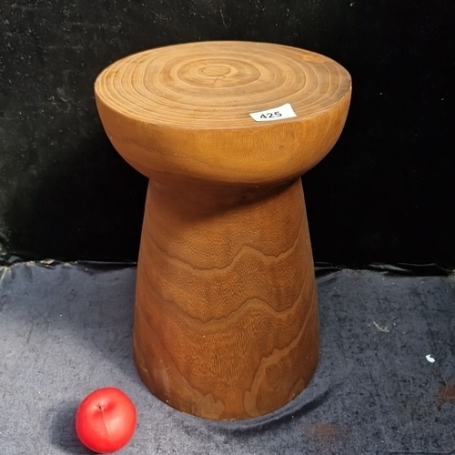 A turned solid wood pedestal stool, plant stand or side table, cylindrical body flaring to a flat circular top.