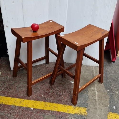 Pair of solid wood bar stools with curved saddle seats and stretchered square legs, late 20th century.