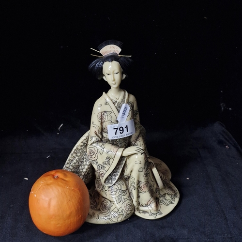A decorative Japanese Geisha composite figure in traditional dress.