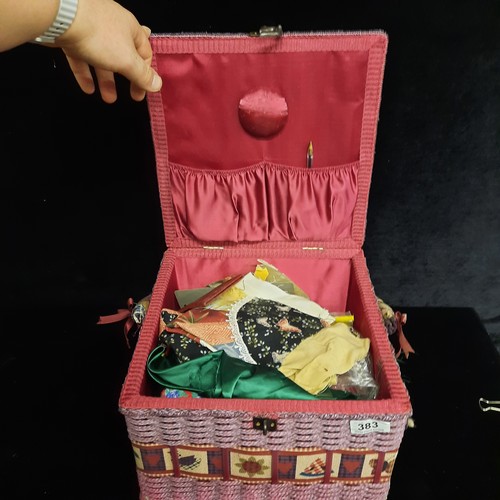 A large wicker sewing box containing a large array of pattern work with ...