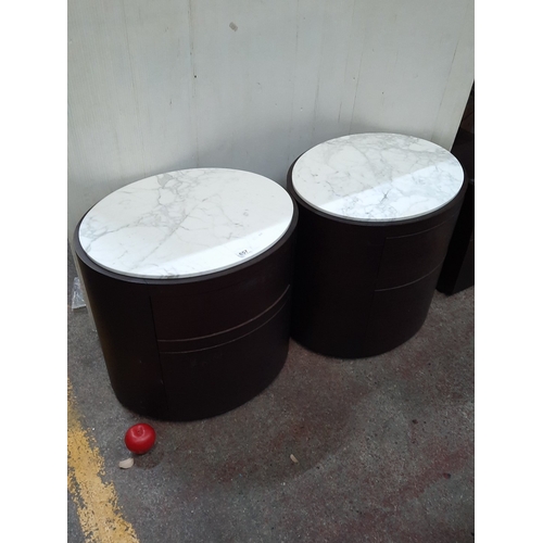 Star Lot : Pair of circular dark wood bedside cabinets with white marble tops, each fitted with a single curved drawer. From the fabulous house in Churchfields in the K club.