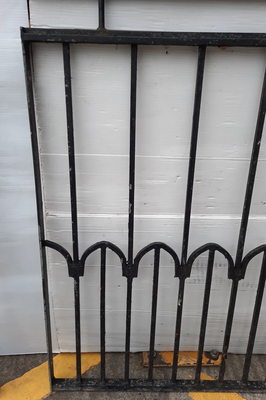Pair of heavy duty black-painted wrought iron railing panels, each with ...