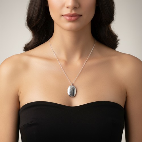 28 - A Sterling Silver large locket pendant and chain with foliate design. Weight - 13 grams.