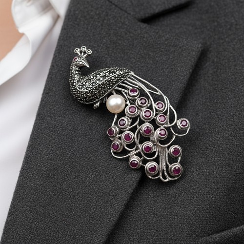 58 - An attractive Peacock Brooch with with Pink Sapphire tail, Pearl accent and marcasite stones through... 