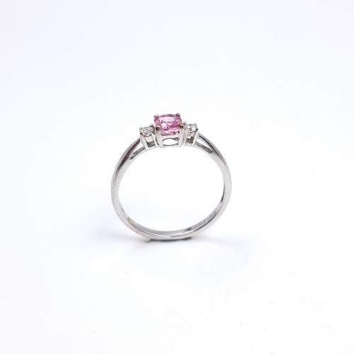 46 - Star Lot : A lovely nine carat white gold ring set with a Pink Sapphire and two Diamonds to shoulder... 