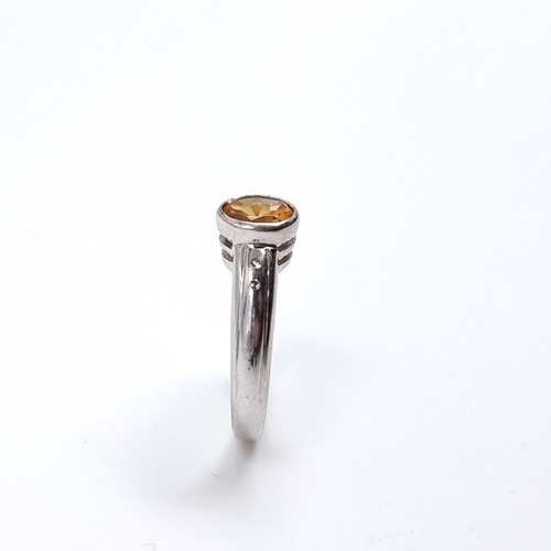 42 - A nine carat white gold ring set with a large Citrine stone. Size - P, Weight - 3.48 grams.