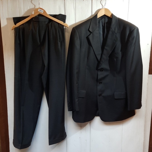 Two-piece black wool suit by Bonacelli for John Taylor, Dublin, tailored in Italian Reda Super 120’s cloth; single-breasted three-button jacket with notch lapels, matching pleated trousers. blazer size 102.
