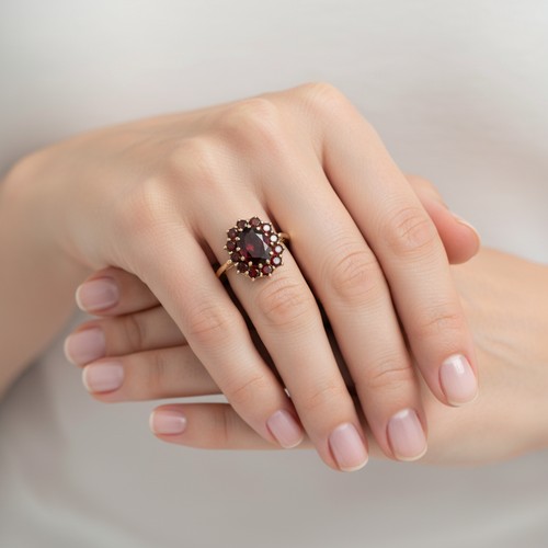 15 - Star Lot: A nice example of a Garnet set flower ring set in nine carat gold. Size  - M 1/2, Weight -... 