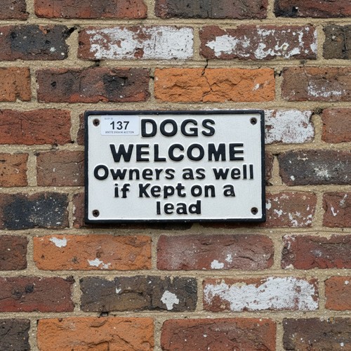 137 - A humorous wall mounted cast metal sign reading 