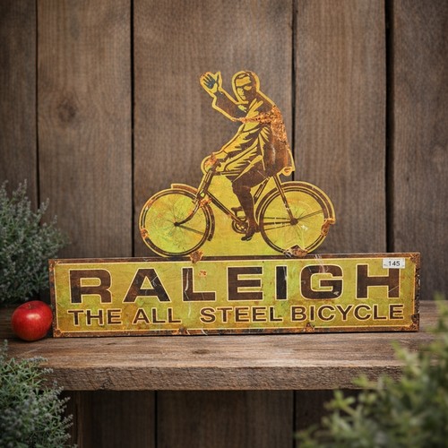 145 - A large printed metal sign reading 'Raleigh' .
Please note, the image of the modelled/ staged item w... 
