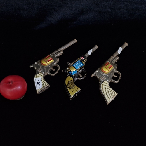 107 - Three vintage tin toy guns including two Japanese 
