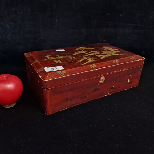 94 - A Japanese lacquered wooden storage box with hand painted gilt accents depicting traditional natures... 