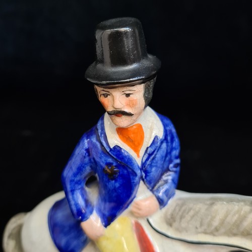 153 - An English 19th century Staffordshire pottery figure depicting a hunter on horseback with hunting do... 