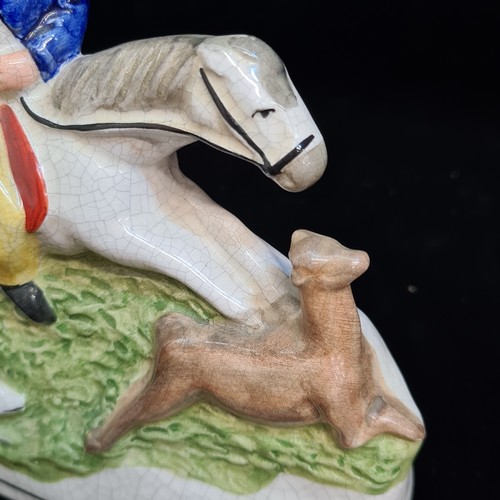 153 - An English 19th century Staffordshire pottery figure depicting a hunter on horseback with hunting do... 