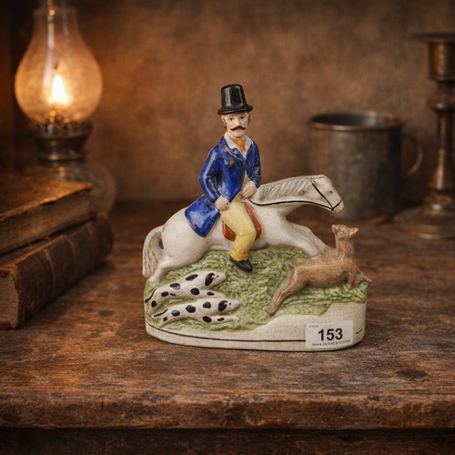 153 - An English 19th century Staffordshire pottery figure depicting a hunter on horseback with hunting do... 