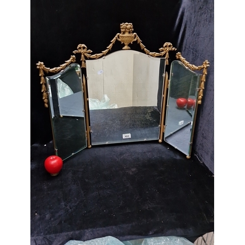 A three-panel dressing-table mirror, with shaped bevelled plates in a gilt metal frame, surmounted by an urn cresting and swags of ribbon-tied laurel, the hinged wings with adjustable mounts.]
Please note, the image of the modelled/ staged item was created by a new imaging/ staging software called showiton.ai. Upload a simple image and the software stages it for you. www.showiton.ai try it for free. It’s a very simple, user-friendly platform.