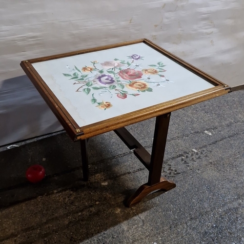 A folding wooden firescreen or occasional table, the glazed panel ...