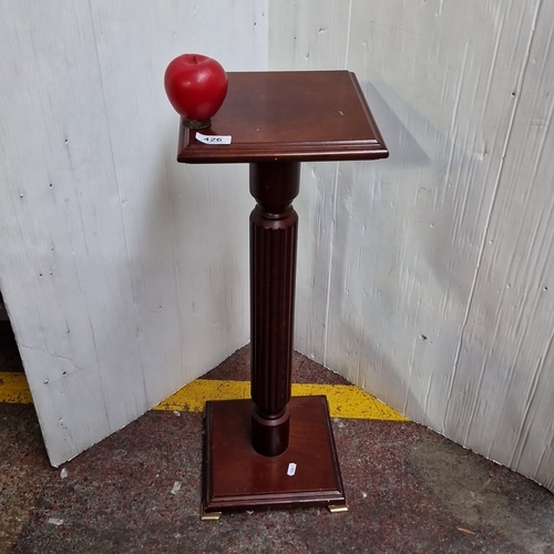 426 - A square-top mahogany pedestal flower pot stand, the moulded top on a fluted column and stepped squa... 