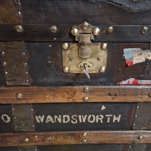 434 - Star Lot : An antique canvas-covered  travelling trunk with timber battens and brass studding, iron ... 