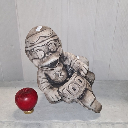 1466 - A heavy cast composition garden figure of a cartoon-style motorcyclist astride a racing bike, with r... 