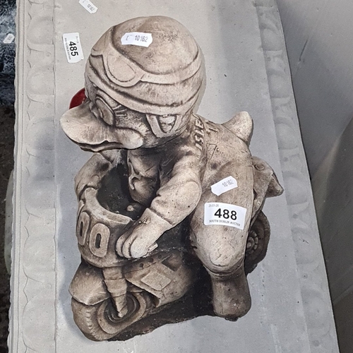 1466 - A heavy cast composition garden figure of a cartoon-style motorcyclist astride a racing bike, with r... 