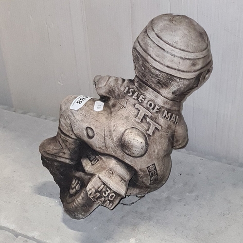 1466 - A heavy cast composition garden figure of a cartoon-style motorcyclist astride a racing bike, with r... 