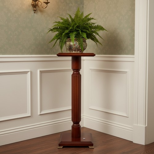 426 - A square-top mahogany pedestal flower pot stand, the moulded top on a fluted column and stepped squa... 